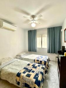 1 dormitorio con 2 camas y ventilador de techo en Apartment Sunny Albir en Albir
