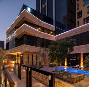 a building with a pool in front of it at Bristoria Hotel Erbil in Erbil