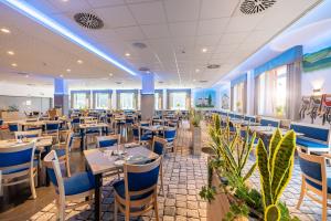 a restaurant with tables and chairs and plants at Hotel Am Bühl in Eibenstock