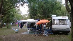 uma bicicleta estacionada debaixo de um guarda-chuva ao lado de um camião em Camping Ulisse Calabria em Lamezia Terme