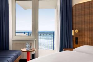 - une chambre avec un lit et une vue sur l'océan dans l'établissement Vienna House by Wyndham Amber Baltic Miedzyzdroje, à Międzyzdroje