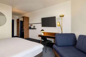 a hotel room with a bed and a desk and a bed and a room with at Vienna House by Wyndham Amber Baltic Miedzyzdroje in Międzyzdroje