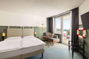 une chambre d'hôtel avec un lit, une table et une fenêtre dans l'établissement Vienna House by Wyndham Amber Baltic Miedzyzdroje, à Międzyzdroje