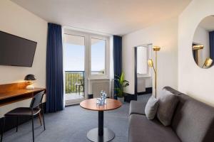 a living room with a couch and a table at Vienna House by Wyndham Amber Baltic Miedzyzdroje in Międzyzdroje