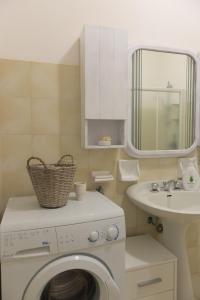 een badkamer met een wasmachine en een wastafel bij Trullo Nonno Marco 2.0 in Cisternino