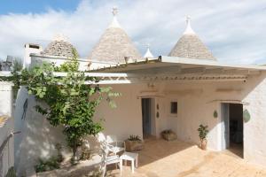 een wit huis met drie piramidevormige daken bij Trullo Nonno Marco 2.0 in Cisternino