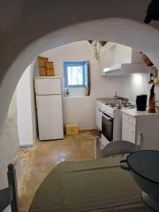 een keuken met een witte koelkast en een fornuis bij Trullo Nonno Marco 2.0 in Cisternino