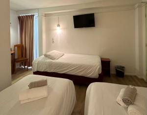 Cette chambre comprend 2 lits et une télévision à écran plat. dans l'établissement HAVANA Hôtel, à Sens