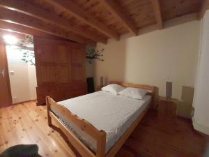 ein Schlafzimmer mit einem Bett und einem Holzboden in der Unterkunft Maison familiale à 10 minutes de Llivia in Angoustrine