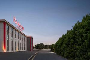 a building with a sign on the side of it at Ramada by Wyndham Karacabey in Bursa