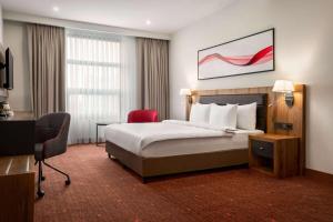 a hotel room with a bed and a desk at Ramada by Wyndham Karacabey in Bursa