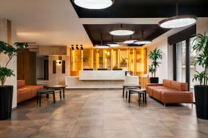 a lobby with orange furniture and a reception desk at Ramada Encore by Wyndham Tashkent in Tashkent