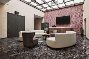 a lobby with couches and chairs and a flat screen tv at Ramada by Wyndham Karacabey in Bursa