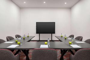 a conference room with two tables and a flat screen tv at Ramada by Wyndham Karacabey in Bursa