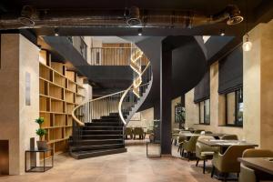 a spiral staircase in a restaurant with tables and chairs at Ramada Encore by Wyndham Tashkent in Tashkent +89 photos