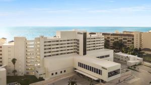 an aerial view of a large white building with the ocean at Hilton Cancun Mar Caribe All-Inclusive Resort in Cancún