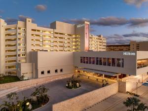 a large white building with a courtyard in front of it at Hilton Cancun Mar Caribe All-Inclusive Resort in Cancún