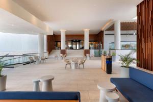 a lobby with tables and chairs in a building at Hilton Cancun Mar Caribe All-Inclusive Resort in Cancún