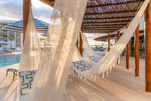 a hammock on a deck next to a pool at Hilton Cancun Mar Caribe All-Inclusive Resort in Cancún