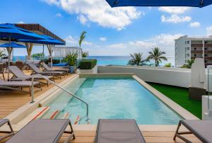 a swimming pool on the roof of a resort with the ocean at Hilton Cancun Mar Caribe All-Inclusive Resort in Cancún