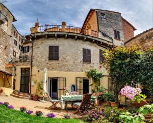 an old building with a table and chairs in a yard at Casagiuliana in Perugia