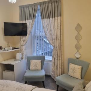 Rose Villa في أوبان: غرفة نوم مع كرسيين ونافذة