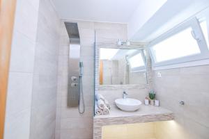 La salle de bains est pourvue d'un lavabo et d'un miroir. dans l'établissement Endless Blue, à Olympiakí Aktí