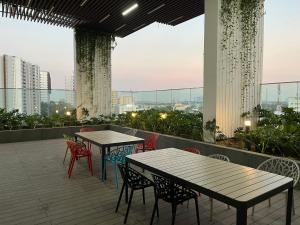 two tables and chairs on the roof of a building at Khu Nghĩ Dưỡng Emerald Golf View in Thuan An