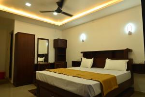 a bedroom with a large bed and a ceiling fan at GR INN in Maraiyūr