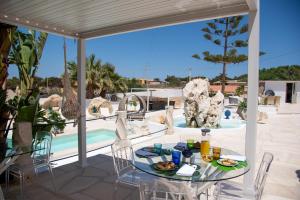 a table with food on it on a patio with a pool at Blue Marine Guest Rooms in Lampedusa