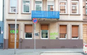 ein Straßenschild vor einem Gebäude mit Graffiti in der Unterkunft Helles Zimmer im Loft in Mannheim
