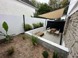un patio con mesa y sombrilla en Arz - 2 pièces neuf proche gare de Vannes, en Vannes