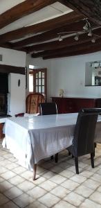 a large white table in a room with two chairs at Valérie GOUFFÉ Chambres d'hotes in Parigné-lʼÉvêque