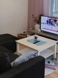 a living room with a white coffee table and a tv at Makasiiniranta in Pori