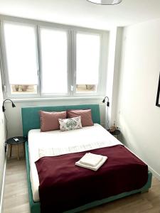 a bedroom with a large bed with two windows at Diamond Apartman Tatabanya in Tatabánya +6 photos