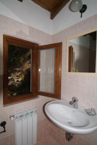 a bathroom with a sink and a window and a mirror at B&B Podere Bramapane in Montelungo Superiore
