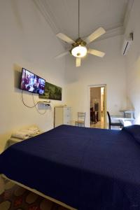 a bedroom with a blue bed and a ceiling fan at A Casa Di Laura in Catania