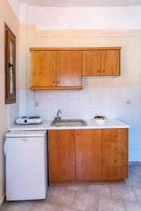 a kitchen with wooden cabinets and a sink and a dishwasher at MON REPOS in Panormos Skopelos