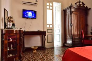 Schlafzimmer mit einem TV an der Wand und einem Bett in der Unterkunft A Casa Di Laura in Catania