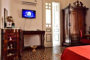 una camera con TV a parete e un letto di A Casa Di Laura a Catania