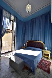 a bedroom with a large bed with blue curtains at A Casa Di Laura in Catania
