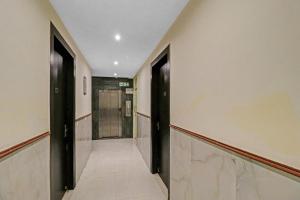 um corredor com duas portas pretas e um elevador em Super Townhouse 990 F Suites Near Delhi Airport em Nova Deli