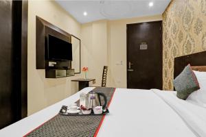 um quarto de hotel com uma cama com uma bandeja de comida em Super Townhouse 990 F Suites Near Delhi Airport em Nova Deli