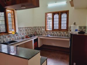 a kitchen with a counter and some windows at Kanna Nivas - Heritage Villa in Thanjāvūr