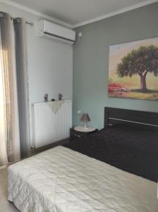 a bedroom with a bed and a tree on the wall at Spartacus Apartment in Alexandroupoli