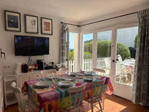 una sala da pranzo con tavolo e TV di Casa con jardín a 25 metros de la playa. LA T. a Palamós