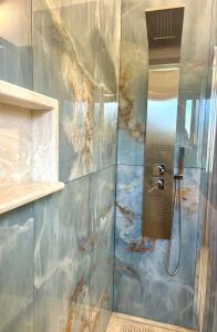 a bathroom with a shower with a painting on the wall at Villa Grecale in Cala Liberotto