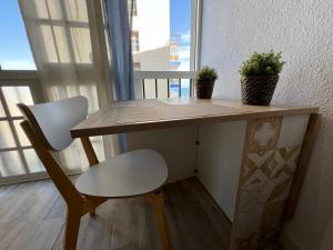 トレモリノスにあるEstudio en La Carihuelaの木製テーブル(椅子、植物2本付)