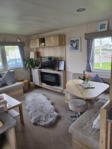 a living room with a couch and a table at Luxury caravan and Tattershall lakes with private hot tub and WiFi in Tattershall