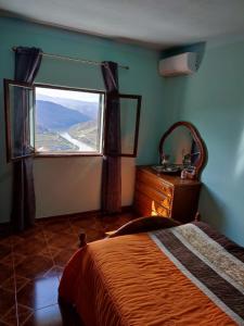 a bedroom with a bed and a large window at Vivenda Casa da Fraga in Alijó